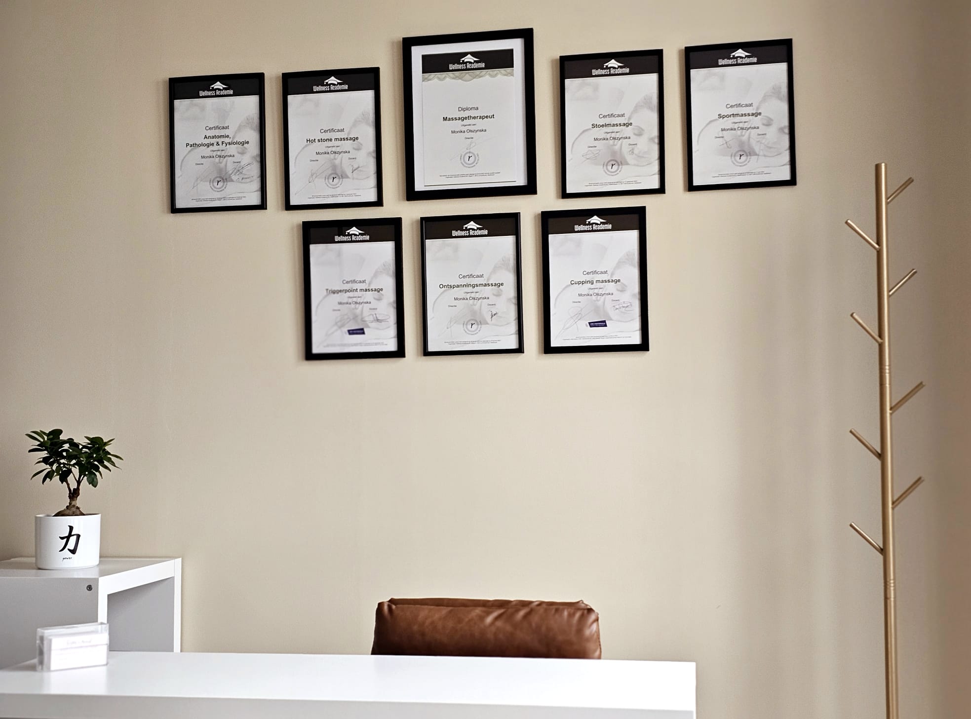 Bureau in de praktijk, met ingelijste certificaten aan de muur
